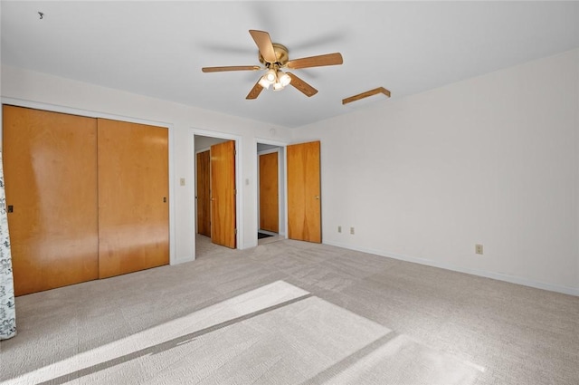 unfurnished bedroom featuring light colored carpet, a closet, ceiling fan, and baseboards
