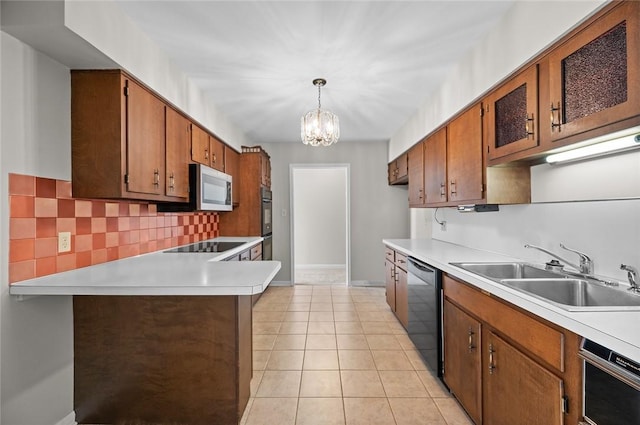 kitchen with a sink, black appliances, light countertops, and backsplash