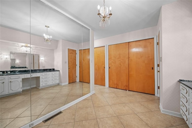 bathroom featuring a chandelier, vanity, tile patterned floors, and baseboards
