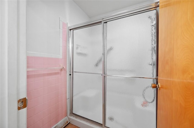 bathroom featuring a stall shower and tile walls