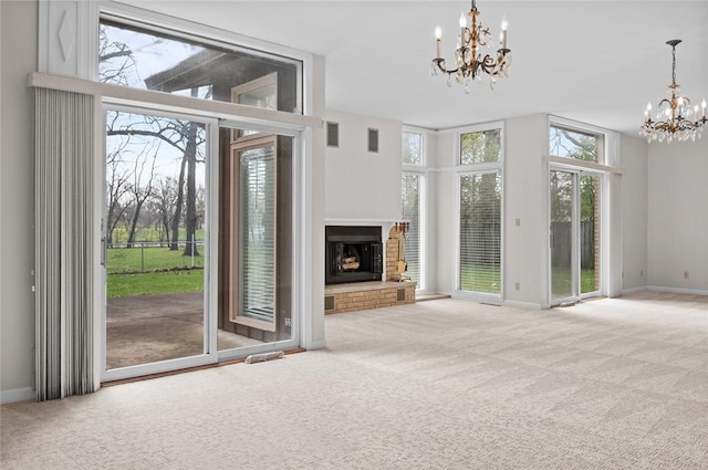 unfurnished living room featuring a chandelier, healthy amount of natural light, and carpet floors