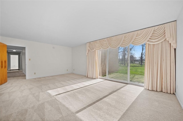 unfurnished living room featuring carpet floors and baseboards