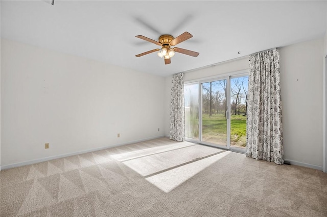 carpeted spare room featuring ceiling fan and baseboards