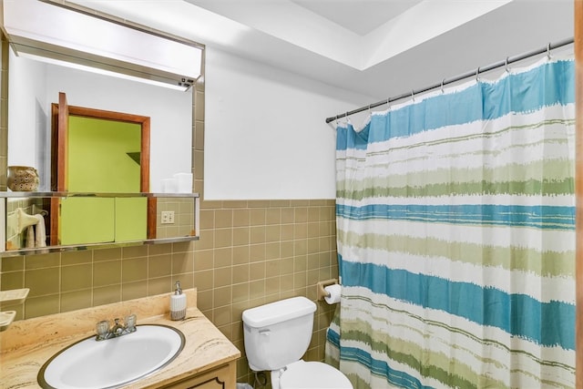 bathroom featuring vanity, curtained shower, toilet, and tile walls