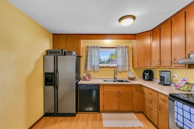 kitchen featuring stainless steel appliances, extractor fan, light hardwood / wood-style floors, and sink