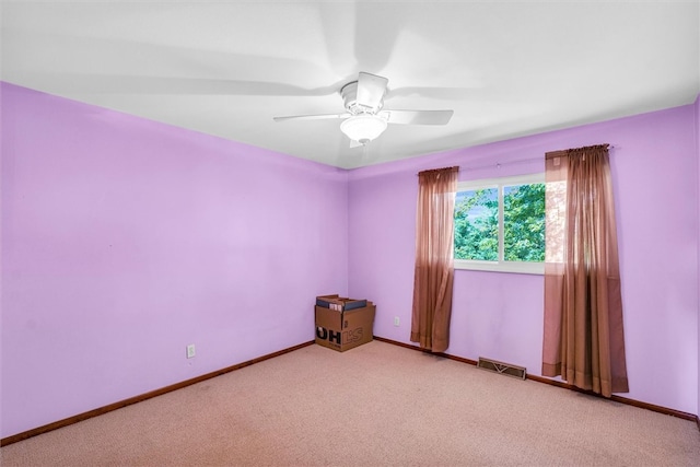 carpeted spare room featuring ceiling fan