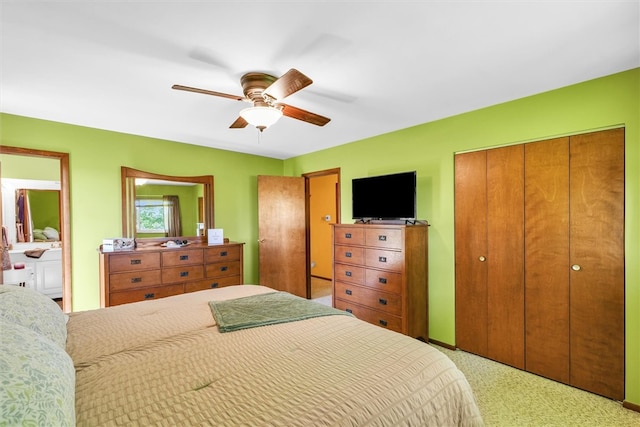 carpeted bedroom featuring ceiling fan and ensuite bath