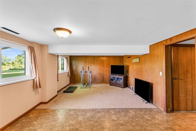 workout area featuring carpet flooring, wooden walls, and a fireplace