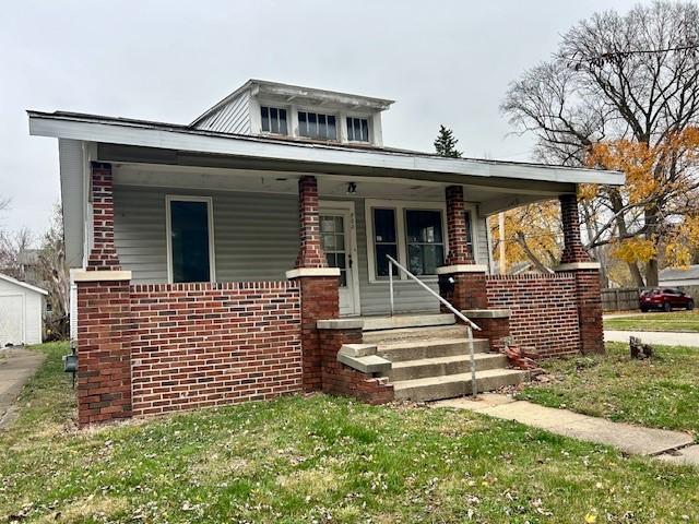 bungalow-style home with a porch and a front yard