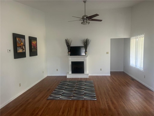 202 S 4th St, Marshall, IL 62441 - unfurnished living room with high vaulted ceiling, a ceiling fan, a fireplace with raised hearth, and wood finished floors