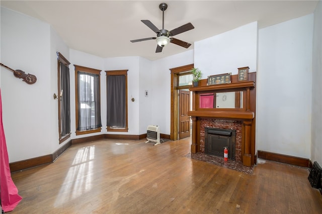 unfurnished living room featuring heating unit, ceiling fan, and hardwood / wood-style flooring