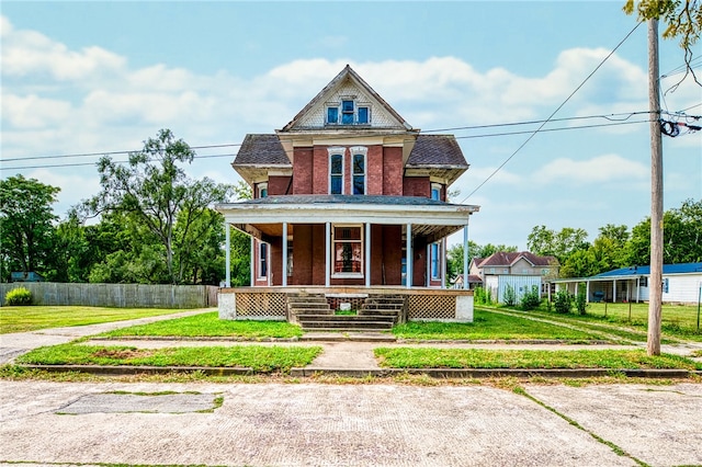 victorian home with a front lawn and covered porch