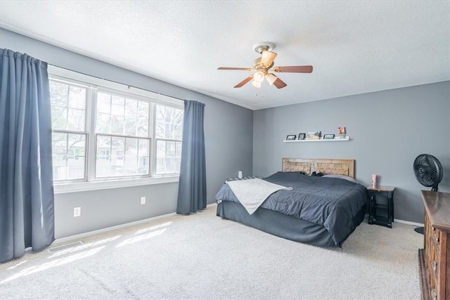 carpeted bedroom with baseboards, a textured ceiling, and ceiling fan