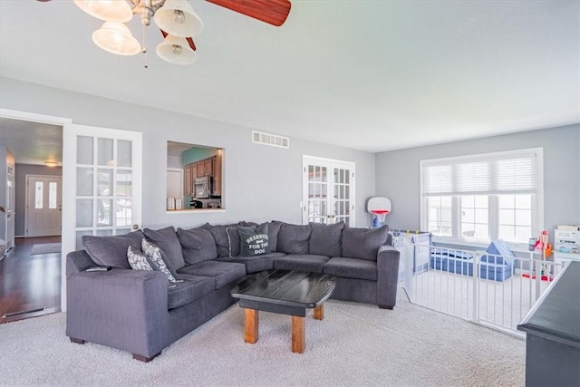 carpeted living room featuring a ceiling fan, french doors, and visible vents