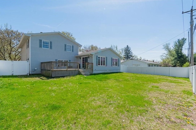 rear view of property featuring a fenced backyard, a yard, and a deck