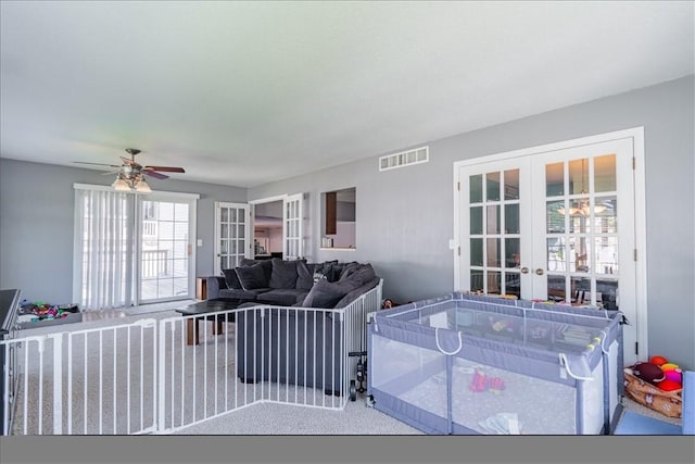 interior space with carpet floors, a ceiling fan, french doors, and visible vents