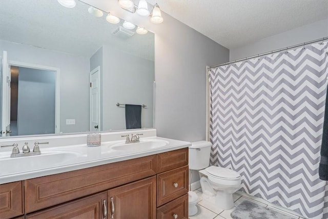 full bathroom with a sink, a textured ceiling, double vanity, and toilet