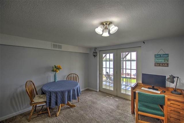 dining space with a textured ceiling, visible vents, french doors, and carpet
