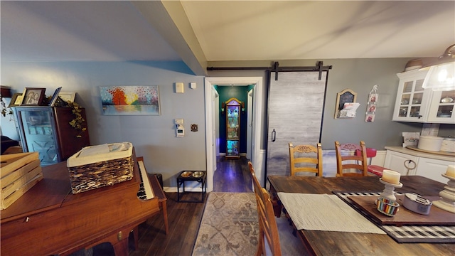 dining space with a barn door and dark hardwood / wood-style flooring