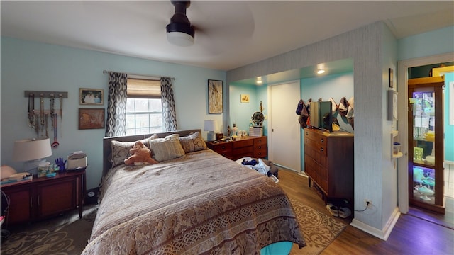 bedroom with ceiling fan and dark wood-type flooring