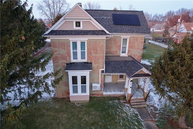 view of front of house with a front yard, solar panels, and french doors