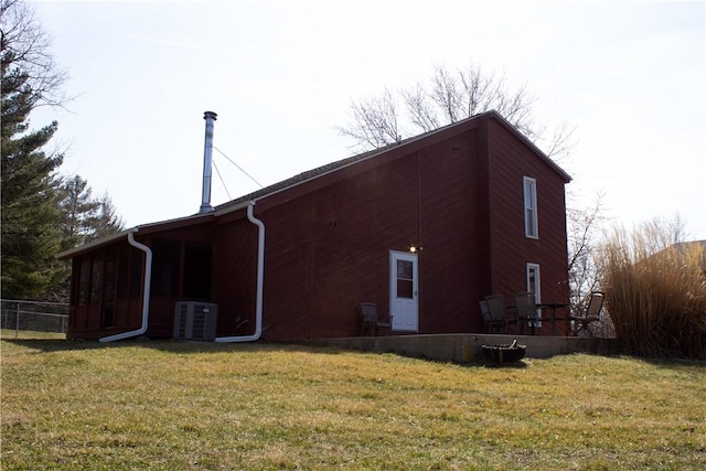 back of property featuring central AC, a yard, and fence