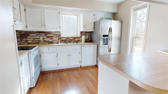 kitchen with decorative backsplash, white appliances, white cabinetry, and a sink