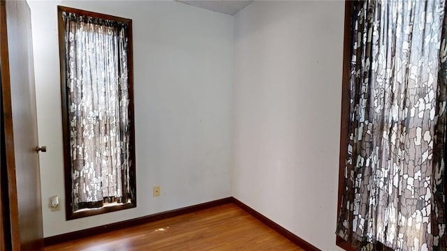 empty room with wood finished floors and baseboards