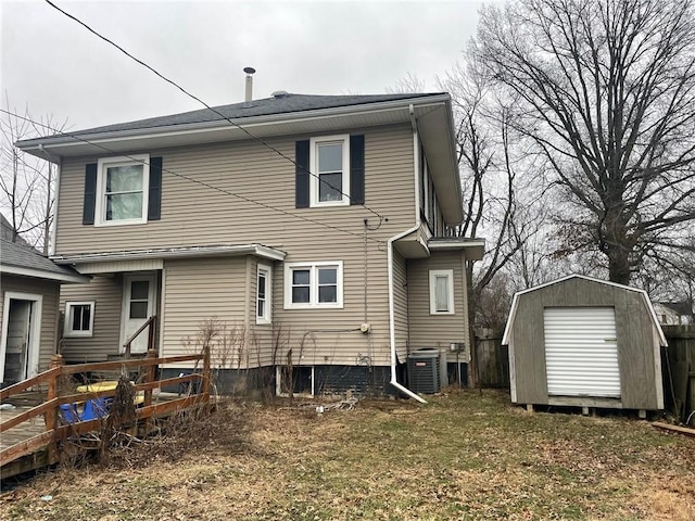 back of house featuring cooling unit and a storage shed