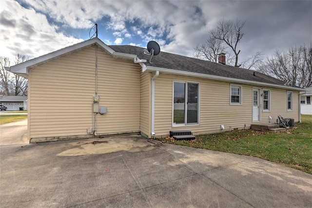 back of house with a patio area and a lawn