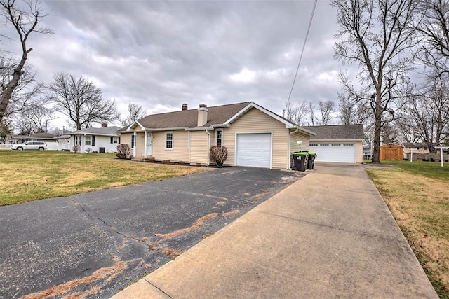 single story home with a garage and a front lawn