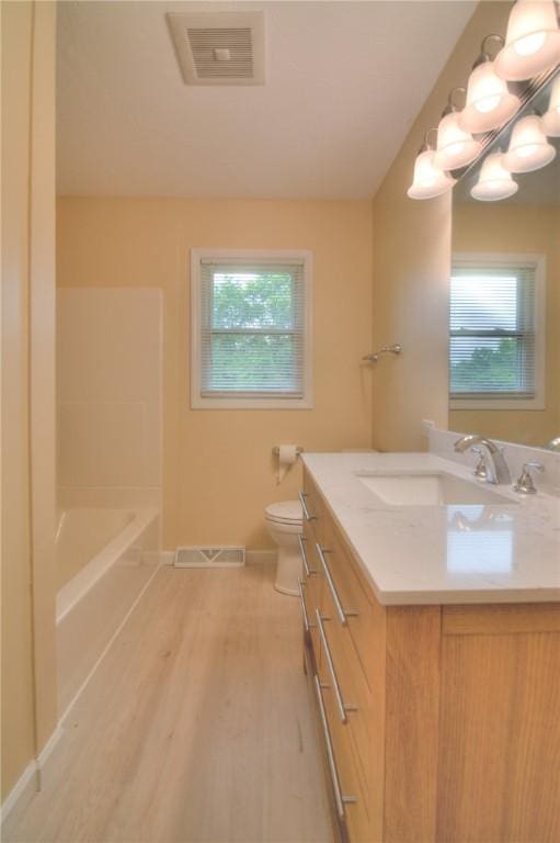 7 Mcdonald Ave, Forsyth, IL 62535 - bathroom featuring vanity, plenty of natural light, wood finished floors, and a bath