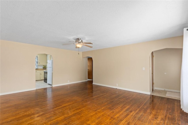 911 Saint Anthony Ave, Effingham, IL 62401 - unfurnished room with arched walkways, a ceiling fan, wood finished floors, and a textured ceiling