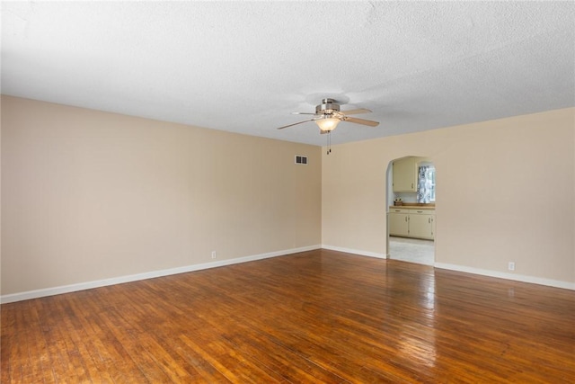 911 Saint Anthony Ave, Effingham, IL 62401 - empty room featuring arched walkways, ceiling fan, wood finished floors, and a textured ceiling