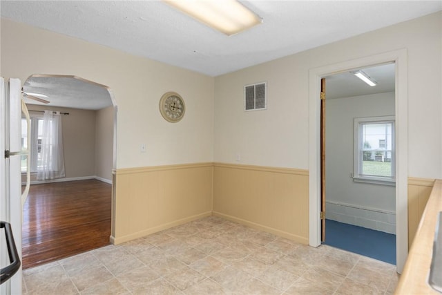 911 Saint Anthony Ave, Effingham, IL 62401 - empty room with wainscoting, arched walkways, and healthy amount of natural light