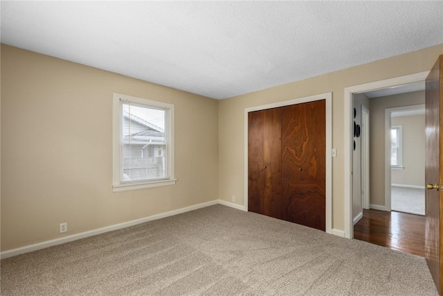 911 Saint Anthony Ave, Effingham, IL 62401 - unfurnished bedroom with carpet floors, multiple windows, a closet, and a textured ceiling