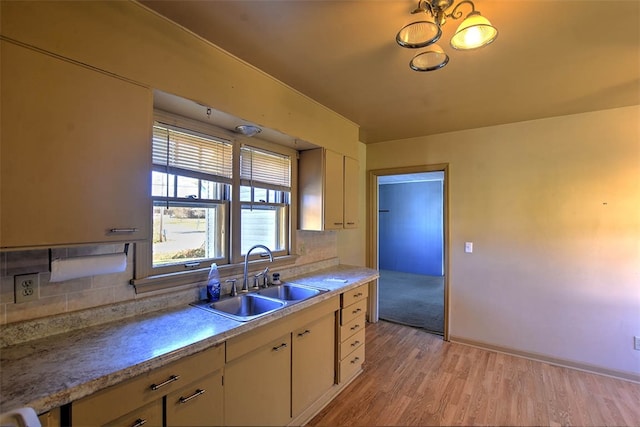 kitchen featuring decorative backsplash, sink, and light hardwood / wood-style flooring