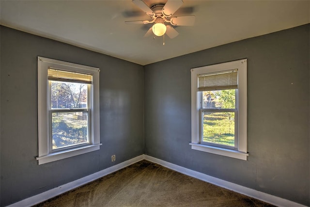 carpeted empty room with a wealth of natural light and ceiling fan