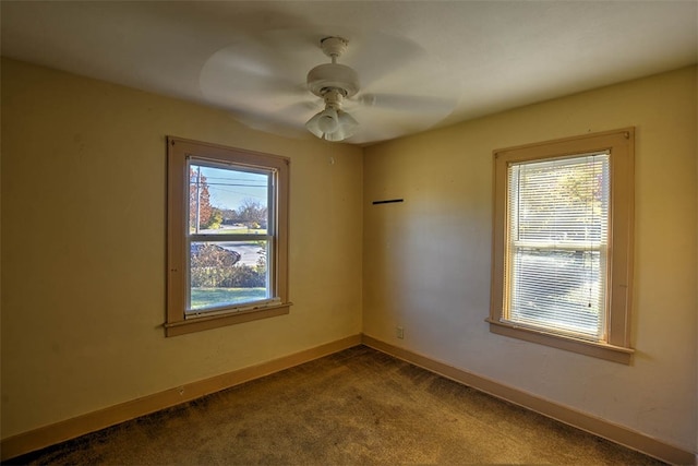 spare room featuring carpet, ceiling fan, and a wealth of natural light