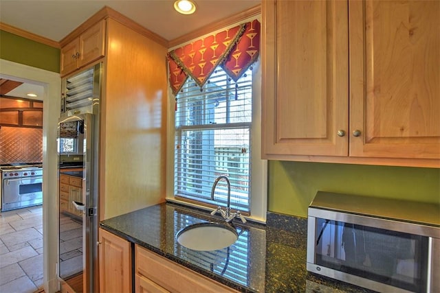 580 Powers Ln, Decatur, IL 62522 - kitchen with appliances with stainless steel finishes, backsplash, dark stone countertops, a sink, and ornamental molding