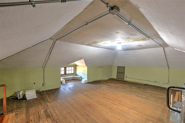 bonus room with hardwood / wood-style floors and lofted ceiling