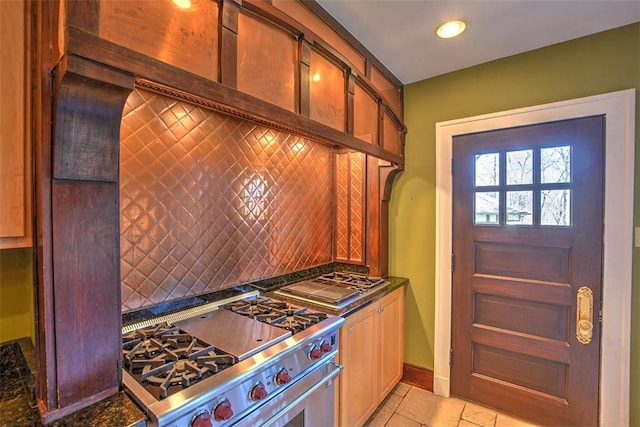 580 Powers Ln, Decatur, IL 62522 - kitchen with stainless steel range, decorative backsplash, dark countertops, light tile patterned floors, and baseboards