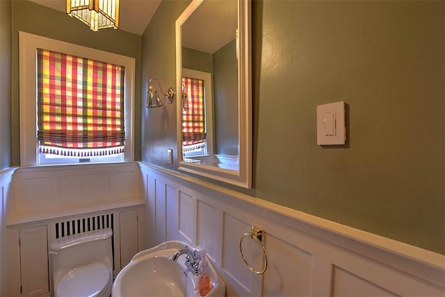 580 Powers Ln, Decatur, IL 62522 - bathroom featuring a decorative wall, toilet, wainscoting, a sink, and a chandelier