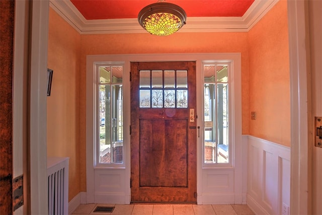 tiled foyer featuring crown molding and a wealth of natural light