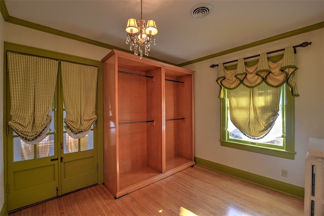 foyer entrance featuring ornamental molding, light hardwood / wood-style floors, and an inviting chandelier