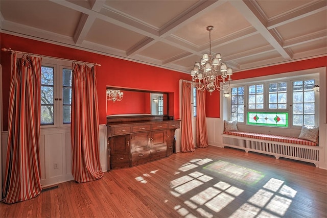 interior space featuring hardwood / wood-style floors, radiator, coffered ceiling, beamed ceiling, and a chandelier