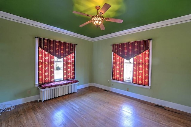 580 Powers Ln, Decatur, IL 62522 - unfurnished room with ornamental molding, a ceiling fan, wood finished floors, baseboards, and radiator heating unit
