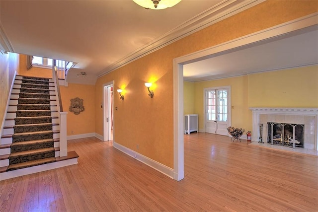 580 Powers Ln, Decatur, IL 62522 - unfurnished living room featuring ornamental molding, wood finished floors, stairs, baseboards, and a tile fireplace