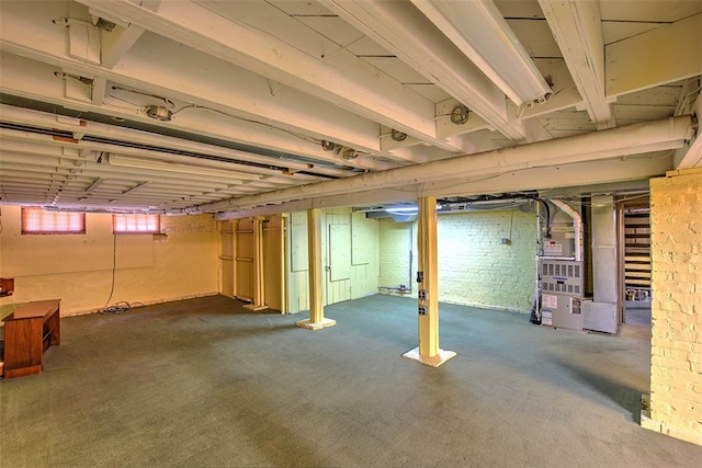 basement featuring carpet flooring and brick wall