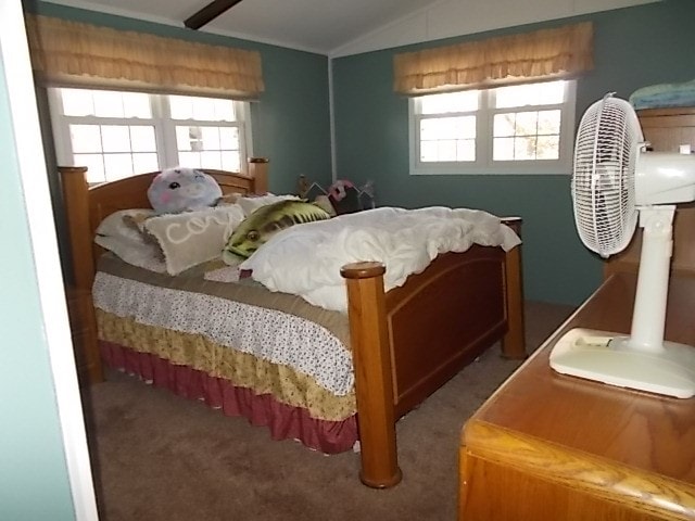 bedroom featuring multiple windows, dark carpet, and lofted ceiling